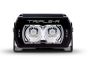 Front view of the lamp face showing the lens and central light source, with the housing and bezel clearly visible.